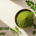 Moringa Benefits: Discover the Power of the Miracle Tree Vibrant green Moringa leaf powder presented in a rustic wooden spoon or bowl on a clean surface, illustrating a common way to consume Moringa.