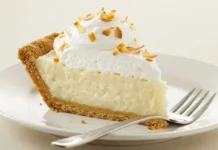 Coconut Cream Pie Recipe: Guide to Classic Homemade Pie A slice of Coconut Cream Pie on a plate showing the crust, creamy filling, and whipped topping layers.