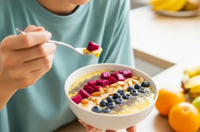 Person happily eating a red dragon fruit smoothie bowl, illustrating the enjoyable health benefits of this tropical fruit.