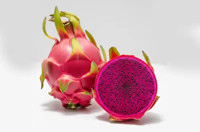 Whole and sliced red dragon fruit (pitaya) showcasing vibrant magenta flesh and black seeds, illustrating its appearance.